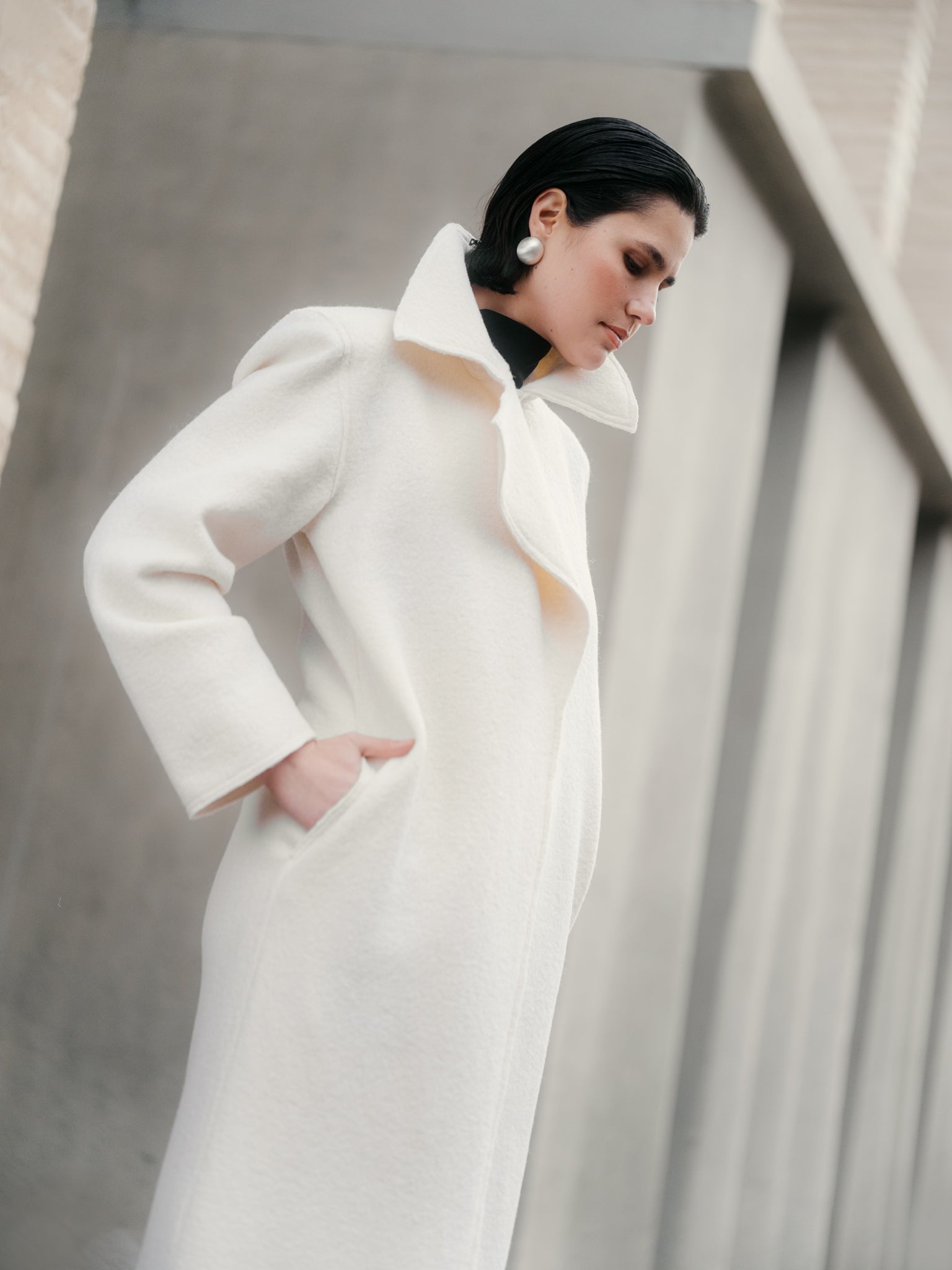 Model wearing Off-white boiled wool long coat by Zamsee—timeless, warm, and consciously crafted.